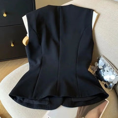 Black sleeveless top on a chair with a neutral background