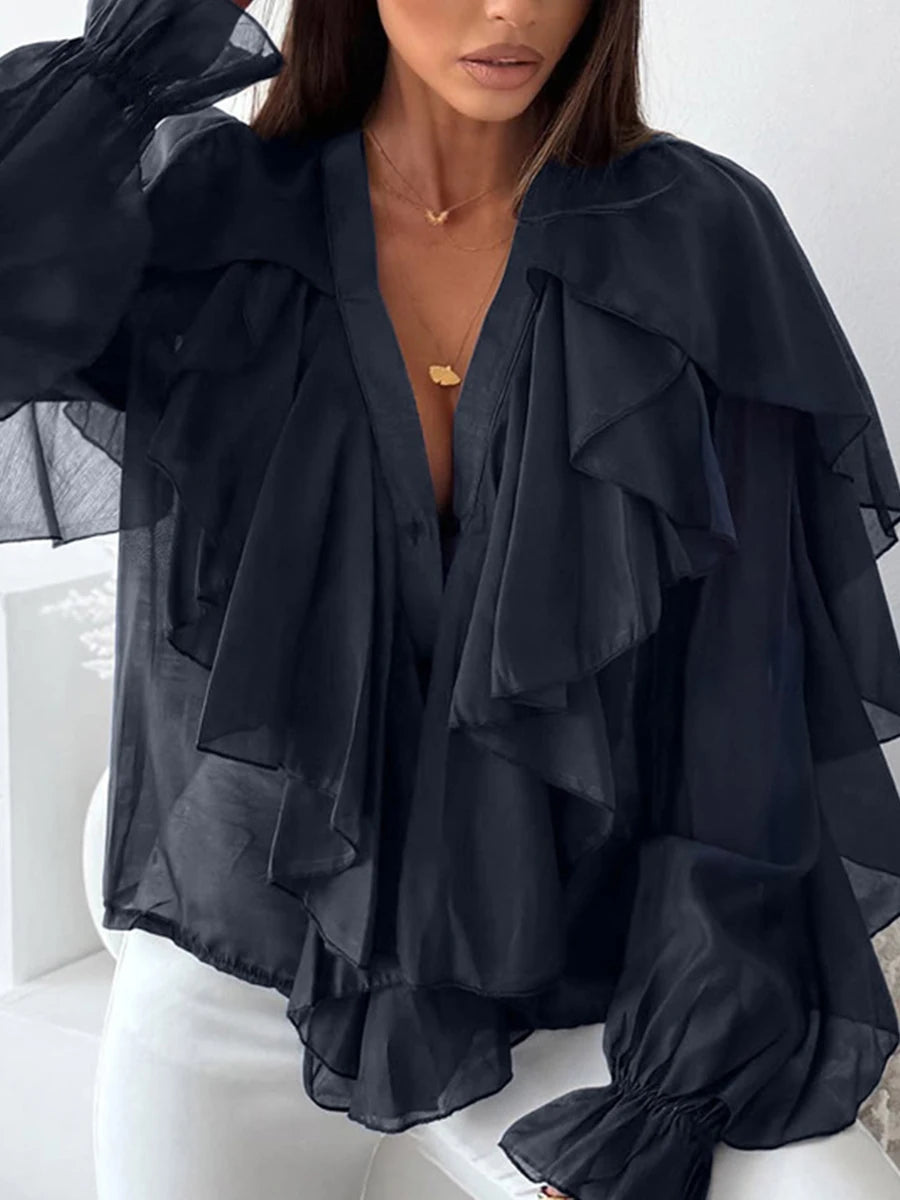 Black ruffled blouse worn by a person on a white background