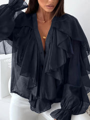 Black ruffled blouse worn by a person on a white background