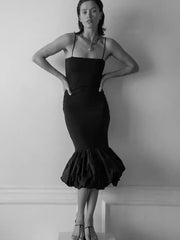 Woman wearing a black dress against a plain background