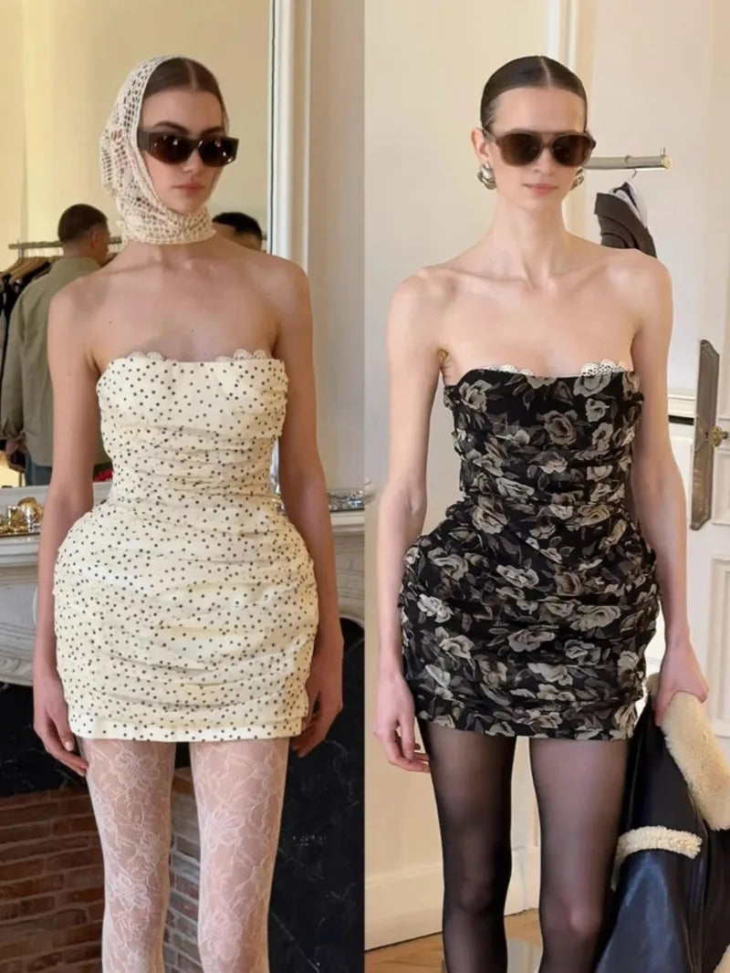 Two women wearing strapless dresses with different patterns in an indoor setting.