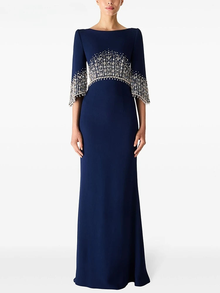Navy blue evening gown with silver embellishments on a white background