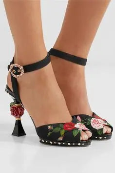 Close-up of floral sculpted heel sandals on a model