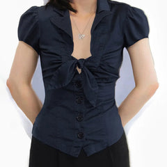 Navy blue blouse with puff sleeves and a bow detail on a white background