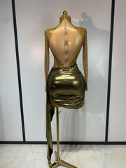 Back view of gold long sleeve turtleneck mini dress with embellishments and draped skirt