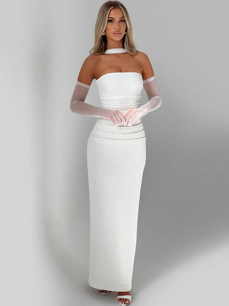 Woman wearing a white off-shoulder dress with sheer gloves on a gray background