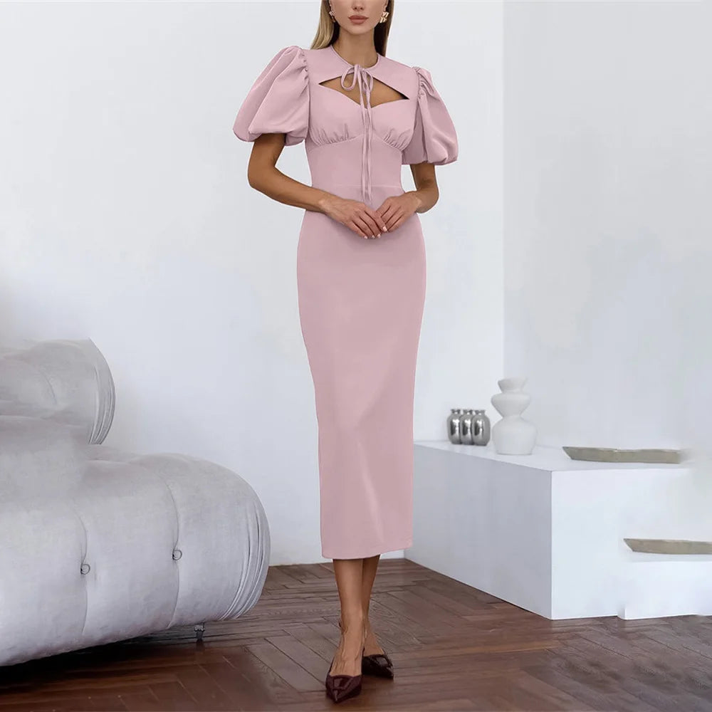 Woman wearing a pink dress in a minimalistic room.