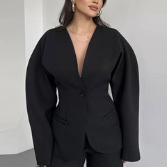 Black blazer worn by a person on a plain background