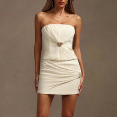 White strapless dress with a decorative brooch on a brown background