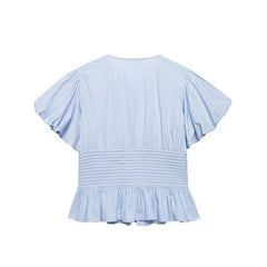 Light blue blouse with ruffled sleeves and bottom on a white background