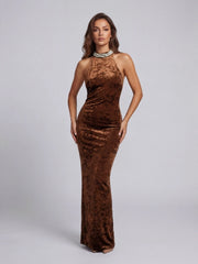 Woman wearing a brown velvet halter neck gown on a gray background