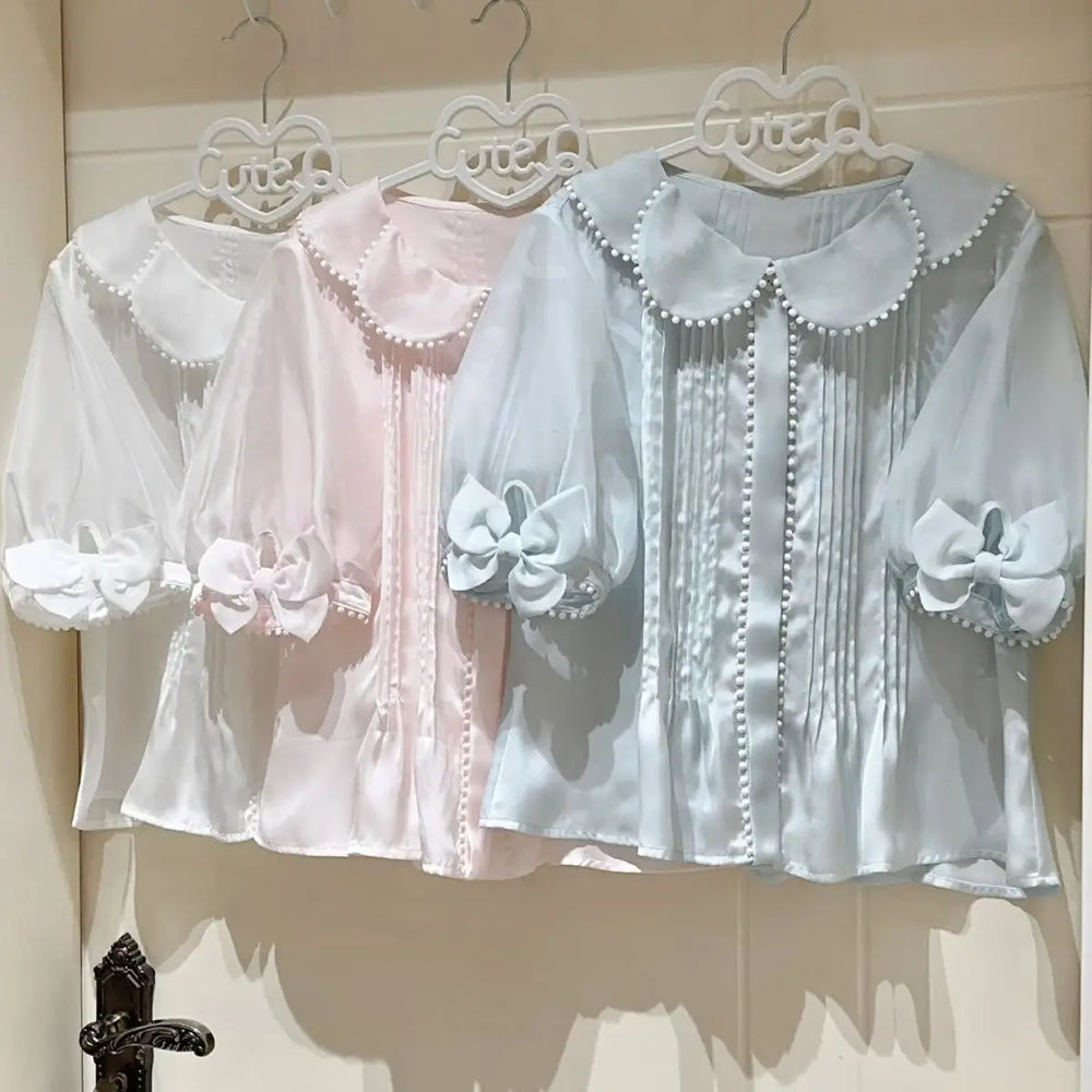 Sheer puff sleeve blouse with a Peter Pan collar and pearl button detail.