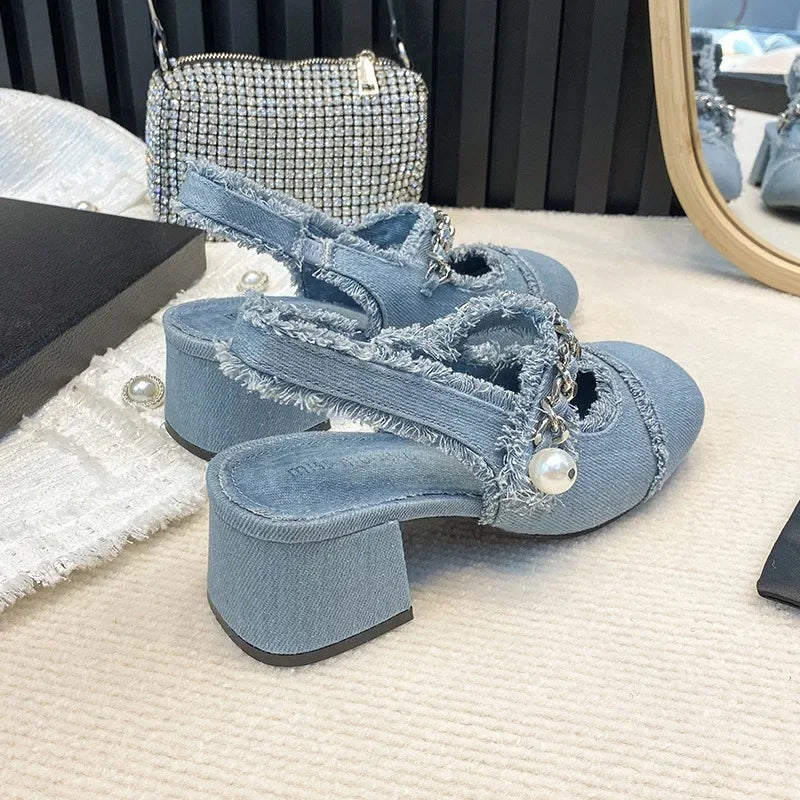 Denim block heel sandals with pearls styled beside crystal clutch