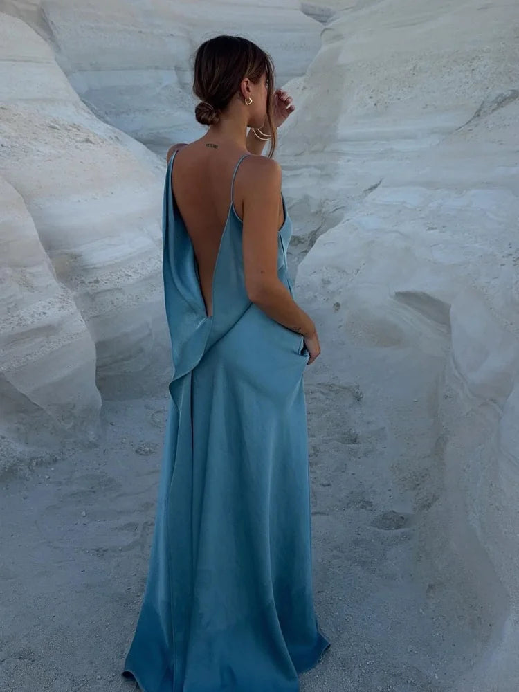 Woman in a blue dress standing in a white sand canyon.