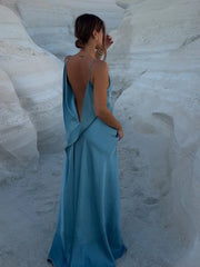 Woman in a blue dress standing in a white sand canyon.
