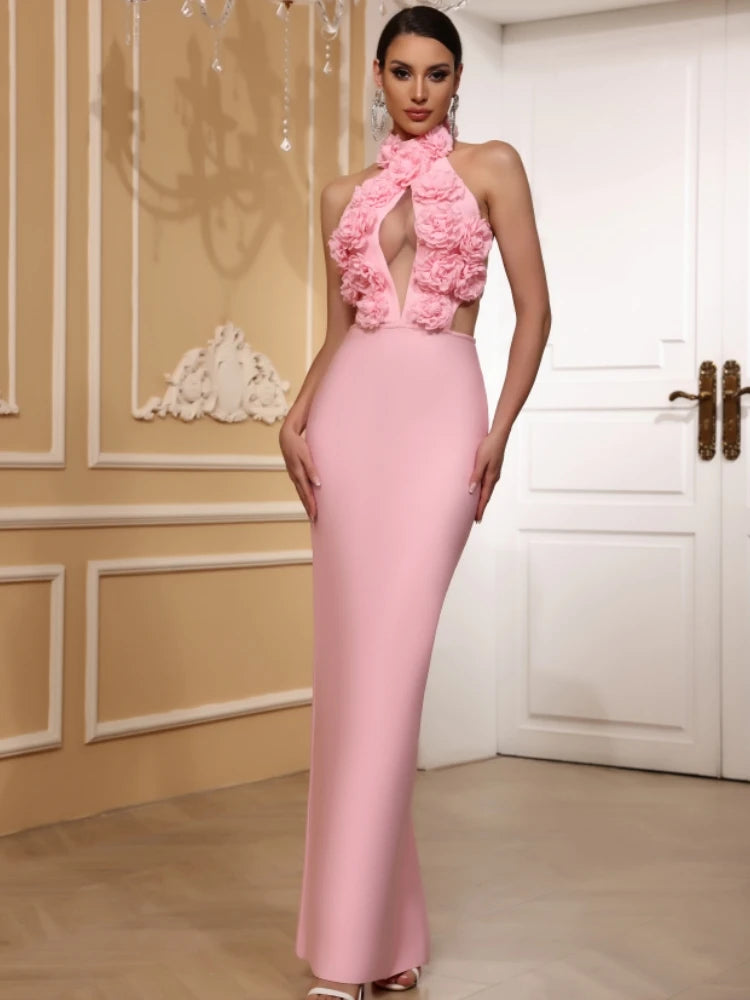 Woman wearing a pink dress with floral details in an elegant room.