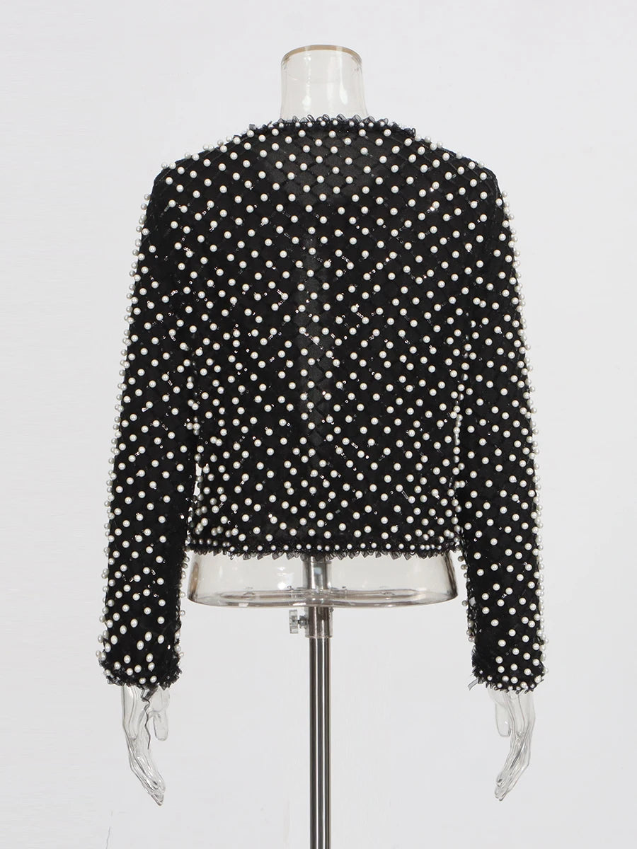 Black beaded top on a mannequin against a white background