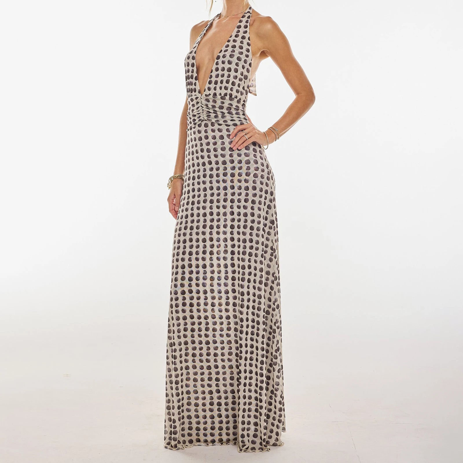 Woman wearing a patterned halter neck dress on a white background