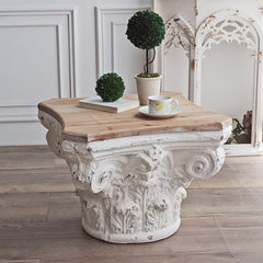 Sculptural pedestal table with antique finish and wood surface in luxury interior