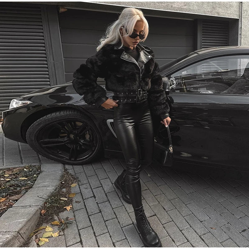 Person in black leather outfit standing next to a black car