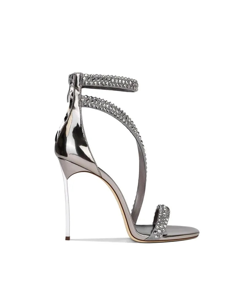 Silver high-heeled sandal with embellishments on a white background
