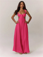A woman wearing a bright pink jumpsuit on a plain background