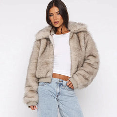 Woman wearing a fluffy beige jacket over a white top and light blue jeans 