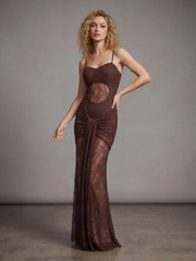 Woman wearing a brown evening gown with a large circular design on a gray background