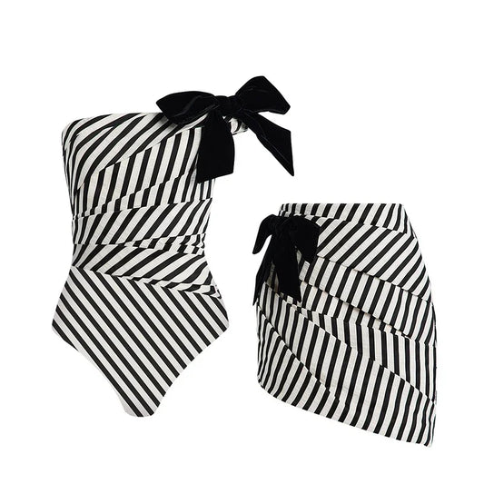 Striped one-piece swimsuit and skirt laid out