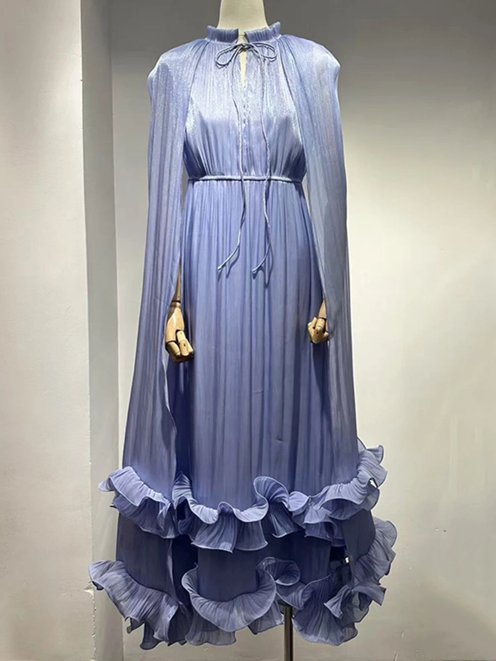 Blue dress with ruffled hem on a mannequin against a plain background