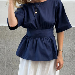 Navy blue top worn by a person against a neutral background