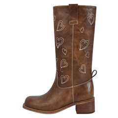 Profile view of brown embroidered heart knee-high boots