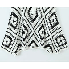 Black and white crocheted blanket with geometric pattern on a light gray background