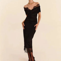 Black off-shoulder dress with lace details on a beige background