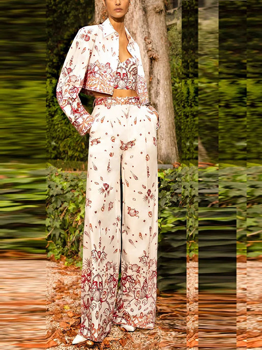 Model wearing a white three-piece suit with a sea world print, consisting of a cropped jacket, camisole, and wide-leg trousers.
