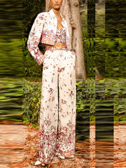 Model wearing a white three-piece suit with a sea world print, consisting of a cropped jacket, camisole, and wide-leg trousers.