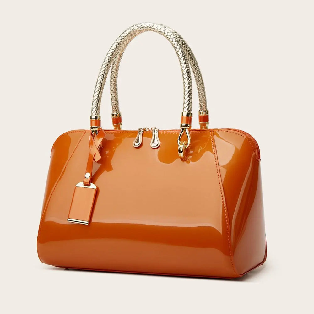 Orange patent leather Boston bag with braided handles.