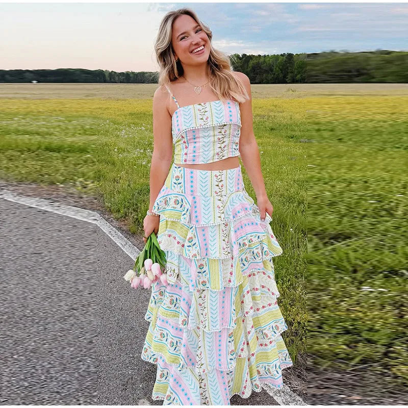 Woman smiling in a printed ruffled crop top and cascading ruffle maxi skirt set outdoors