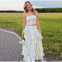 Woman smiling in a printed ruffled crop top and cascading ruffle maxi skirt set outdoors