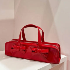 Red patent leather baguette bag with double bow detail and top handles