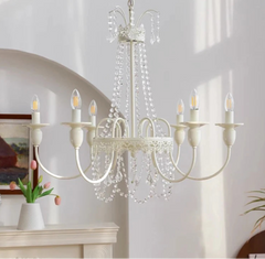 White chandelier with candle-style lights in a room setting