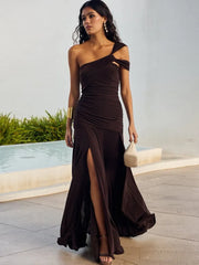 Woman in a brown one-shoulder dress standing by a poolside.
