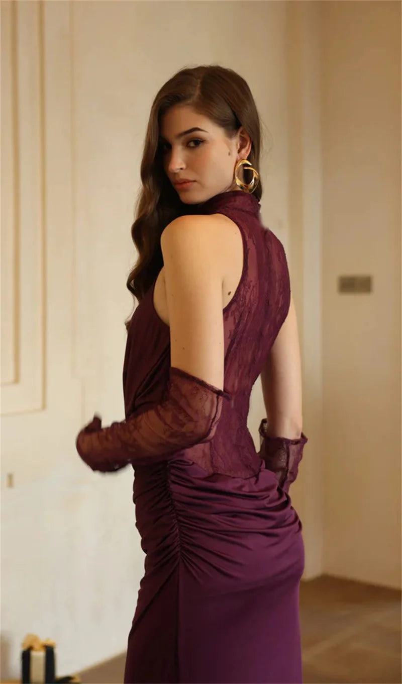 Woman in a burgundy evening gown with sheer sleeves in an indoor setting