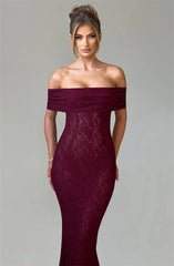 Woman wearing a burgundy off-shoulder lace dress against a gray background