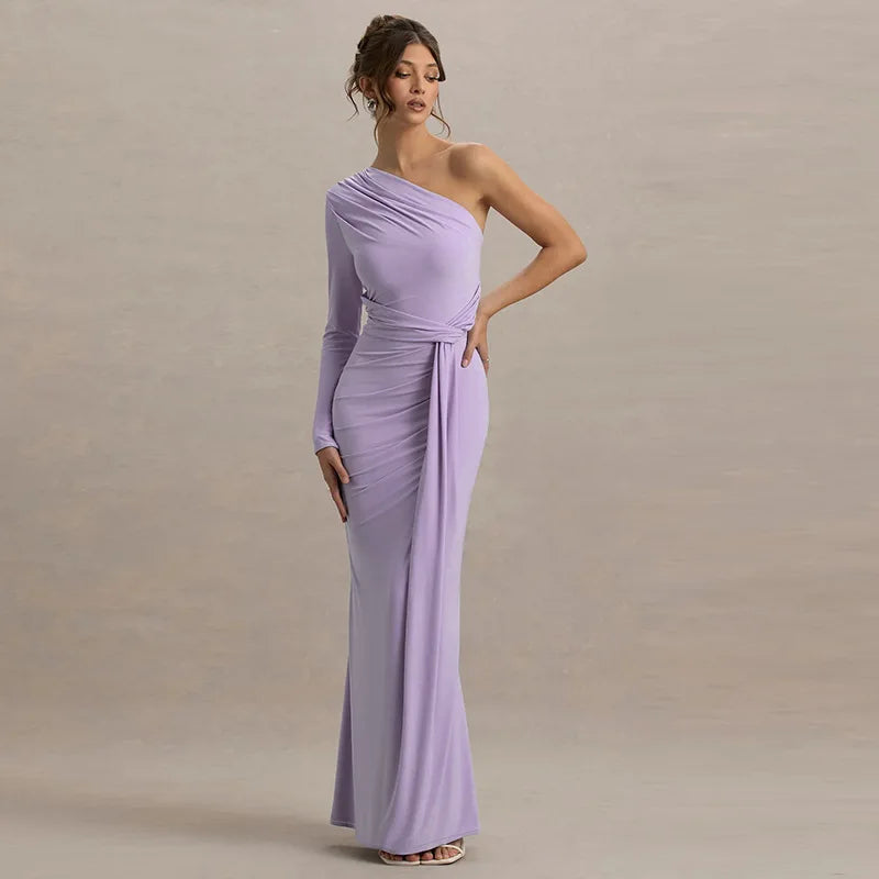 Woman wearing a long, one-shoulder lavender dress against a neutral background