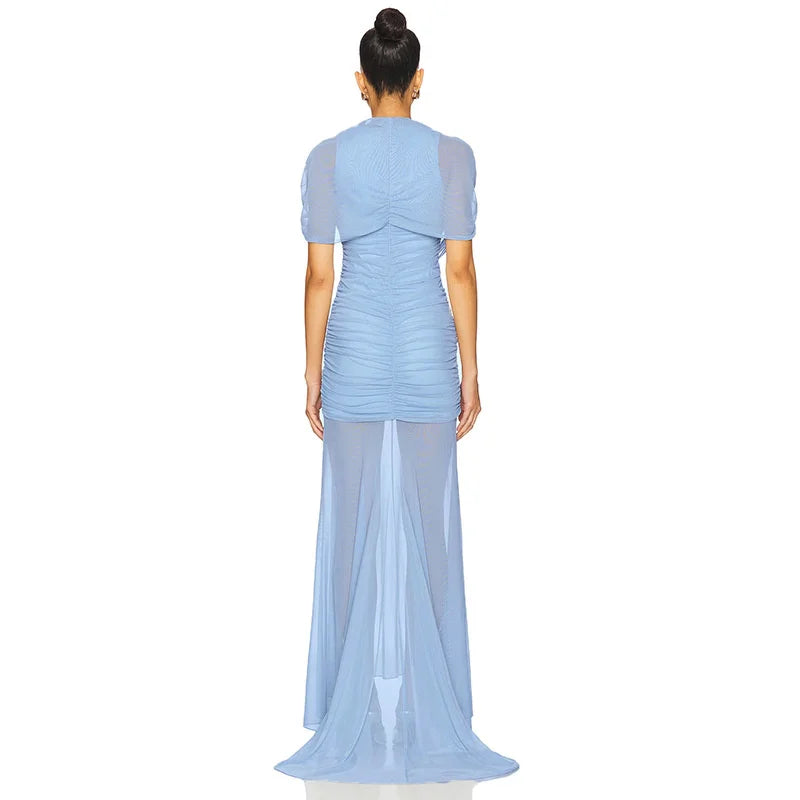 Woman wearing a light blue dress with a sheer overlay on a white background
