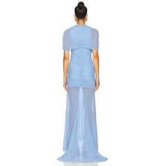 Woman wearing a light blue dress with a sheer overlay on a white background