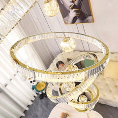 A cluster of sparkling crystal pendant lights illuminating a modern living room. Golden Atelier 4