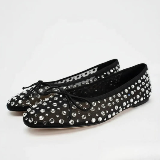 Pair of black mesh ballet flats adorned with sparkling crystals.