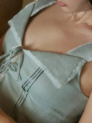Light blue lace-trimmed top worn by a person, with a blurred background.